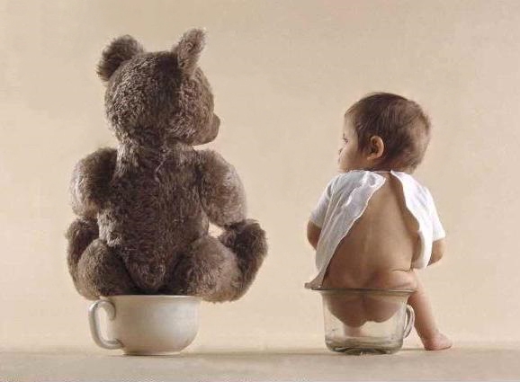Atoddler and his teddy both sitting on their potties