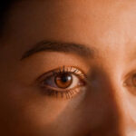 Female human eye details. Studio shot of woman putting on make up