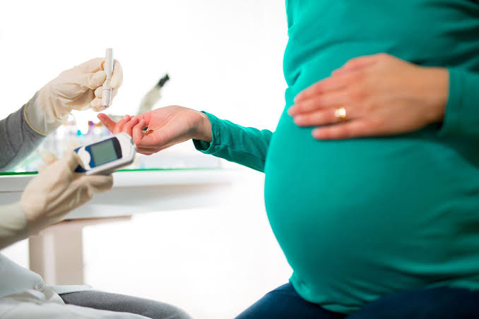 A picture showing a pregnant woman testing for diabetes during pregnancy.
