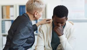 A grieving man being supported by a friend
