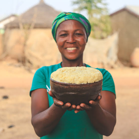 A northern woman holding a bowl of yellow sheabutter
