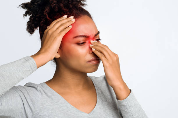 woman with headache touching face